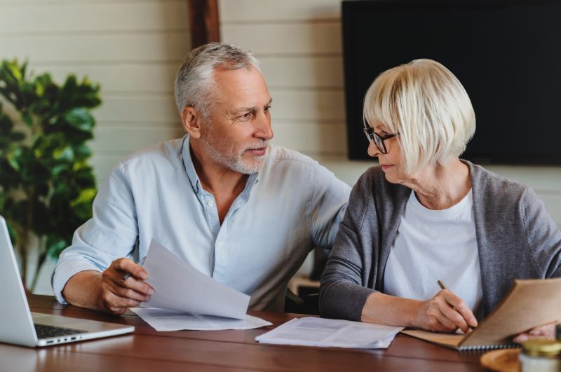 A mature couple talking and looking at paperwork together