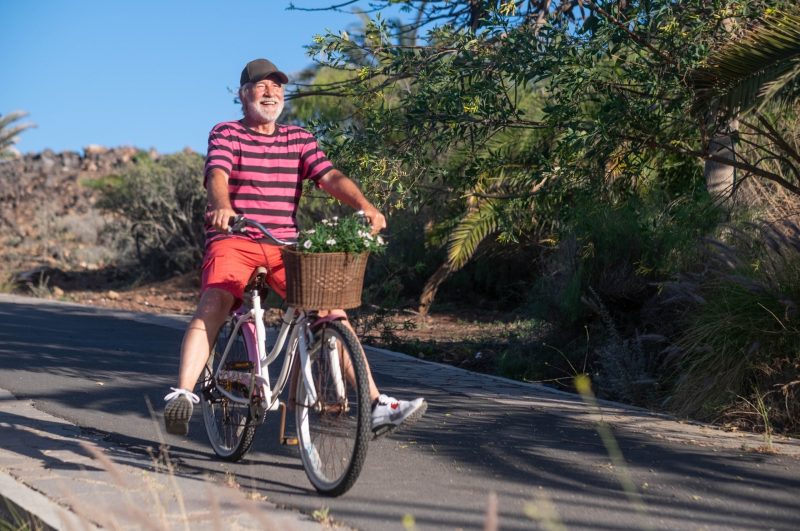 Happy senior man riding a bicycle